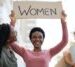 Cheerful black woman holding placard, fighting for women rights