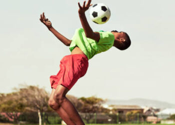 Shot of a young boy playing soccer on a sports field